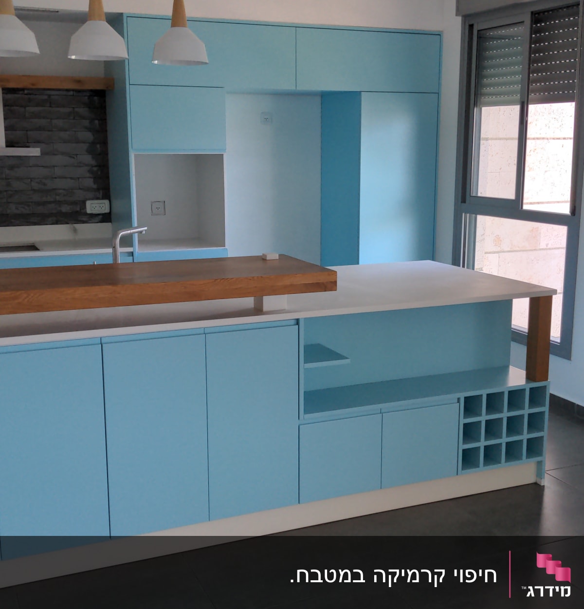 מטבח חדש עם ארונות כחולים ומשטח עץ